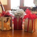 Three shiny silver and red Christmas gift ornaments