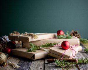 A stack of brown paper wrapped gifts with a dark background
