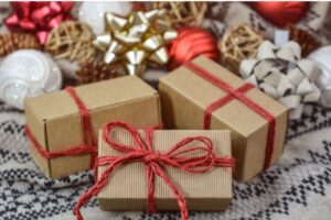 Three rectangular brown paper-wrapped gifts tied with red twiine bows