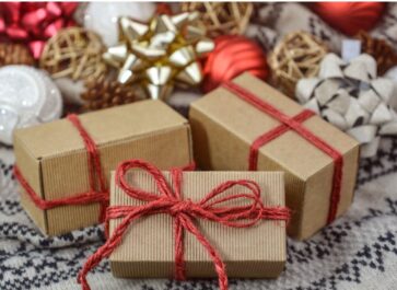 Three rectangular brown paper-wrapped gifts tied with red twiine bows