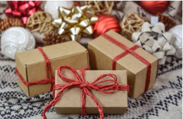 Three rectangular brown paper-wrapped gifts tied with red twiine bows